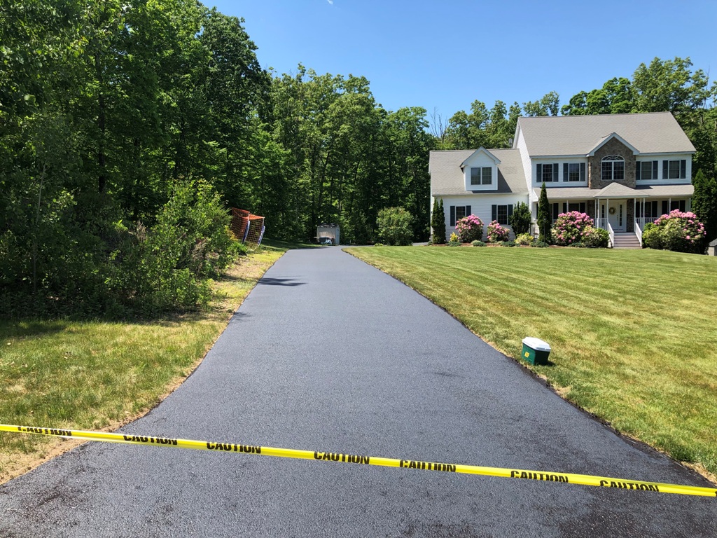Freshly sealed residential driveway with beautiful home